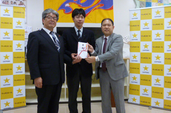 左から：志津川高校 山内校長、生徒会長、当社コーポレートコミュニケーション部部長 梅里